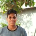 Wonderful Experience! Smiling young man with short hair outdoors in Bangladesh, under a tree.